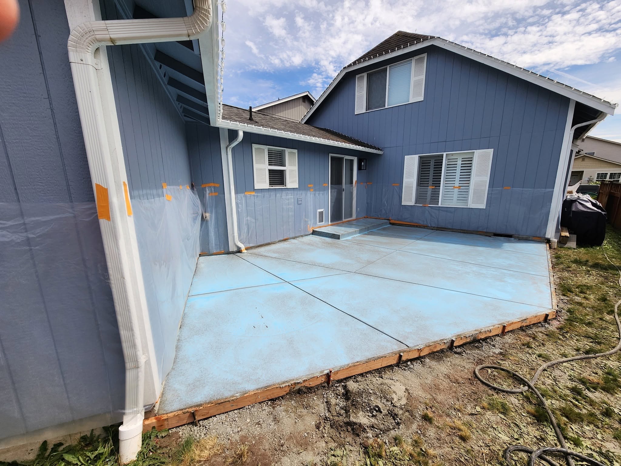 Finished concrete patio at elevated angle against blue house