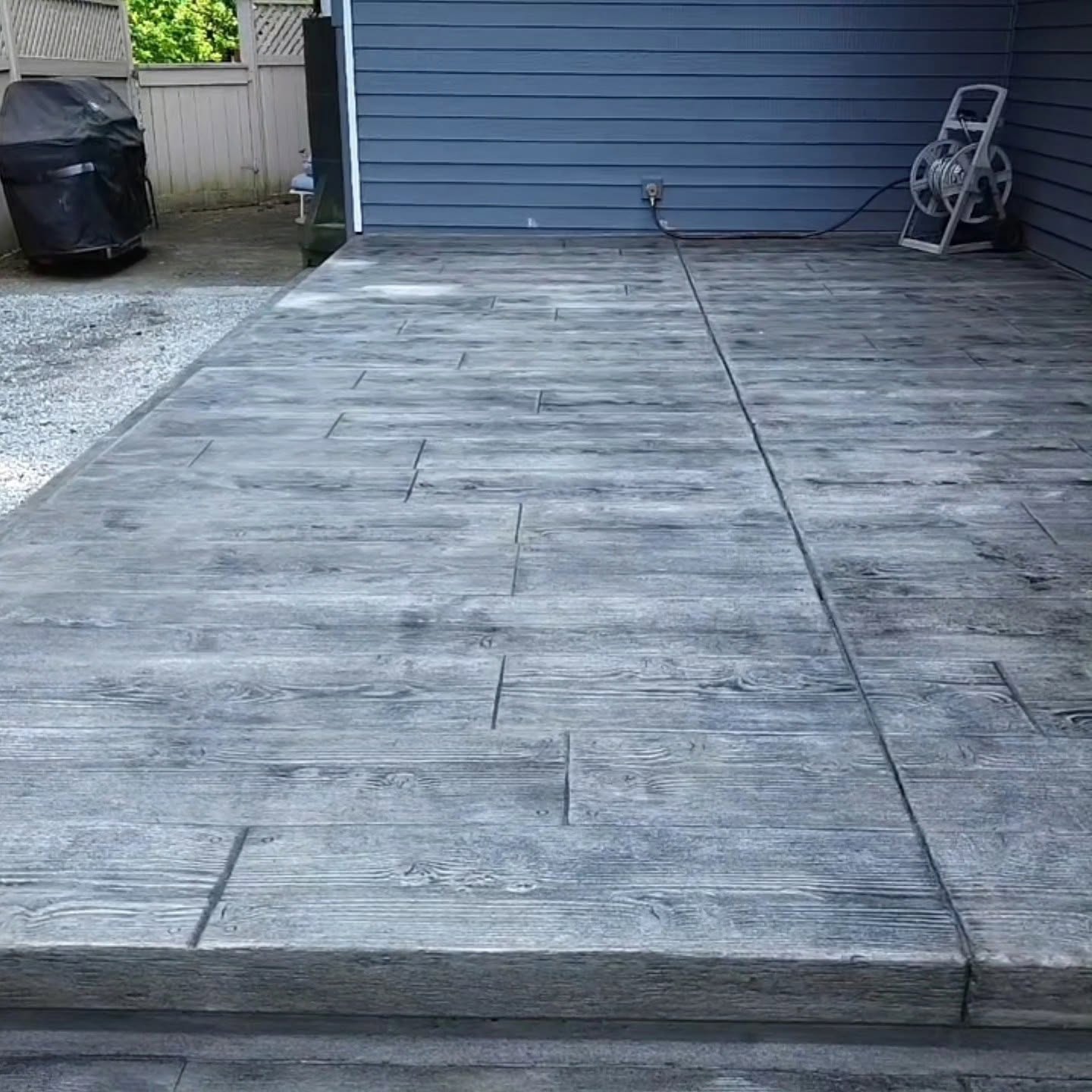 Wood-grain stamped concrete patio wide angle with house